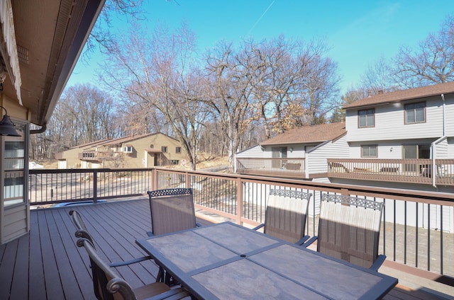 wooden deck with a residential view and outdoor dining area