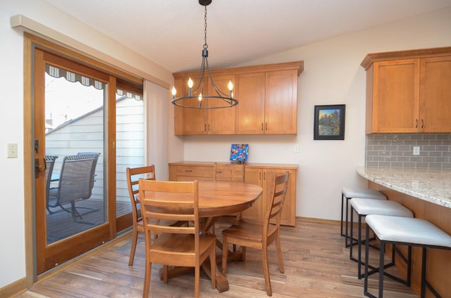 dining space featuring light wood-style flooring and an inviting chandelier