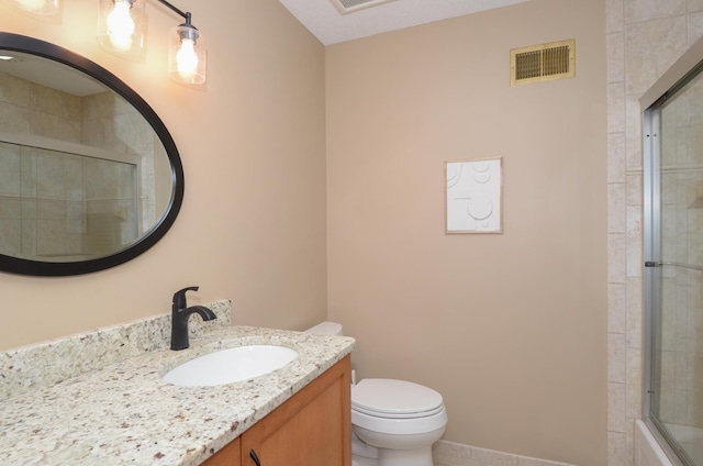 full bath featuring visible vents, baseboards, toilet, tiled shower, and vanity