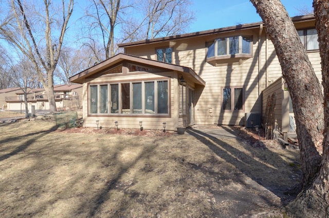 back of house with central AC unit and a sunroom