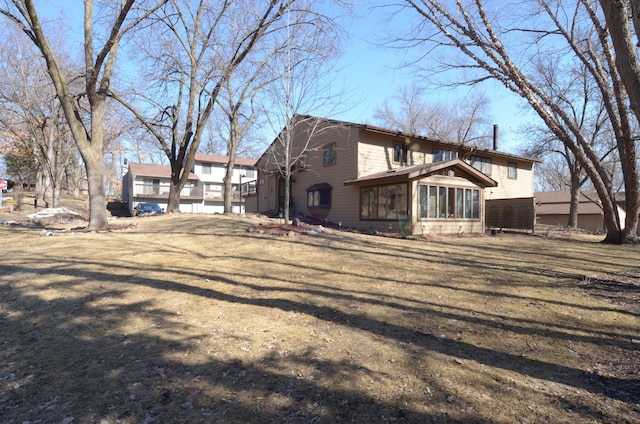 view of front of house with a front yard and a sunroom