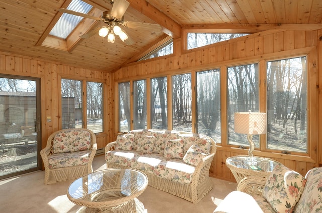 sunroom with lofted ceiling with skylight, wood ceiling, a wealth of natural light, and ceiling fan