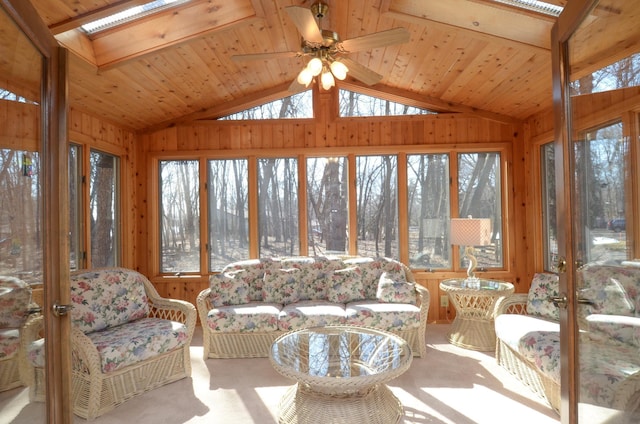 sunroom / solarium with lofted ceiling with skylight, wooden ceiling, and ceiling fan