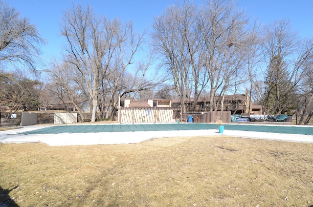 view of swimming pool with a fenced front yard and a lawn