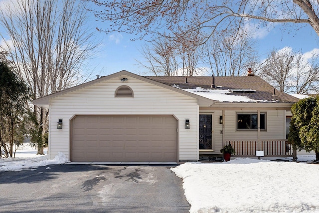 ranch-style home with a garage, driveway, and a shingled roof