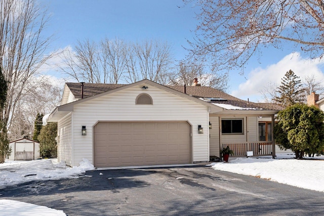 ranch-style house featuring aphalt driveway and a garage