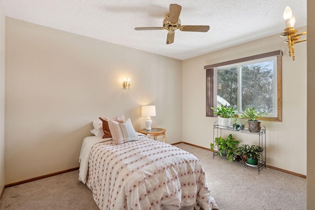 carpeted bedroom featuring baseboards, a textured ceiling, and a ceiling fan