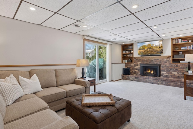 carpeted living area with built in features, visible vents, recessed lighting, and a fireplace