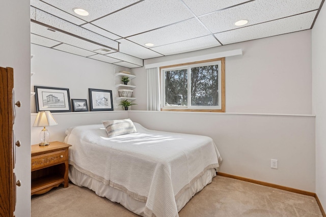 carpeted bedroom featuring visible vents, baseboards, and a drop ceiling