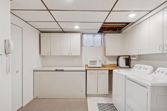 clothes washing area featuring cabinet space and washer and clothes dryer