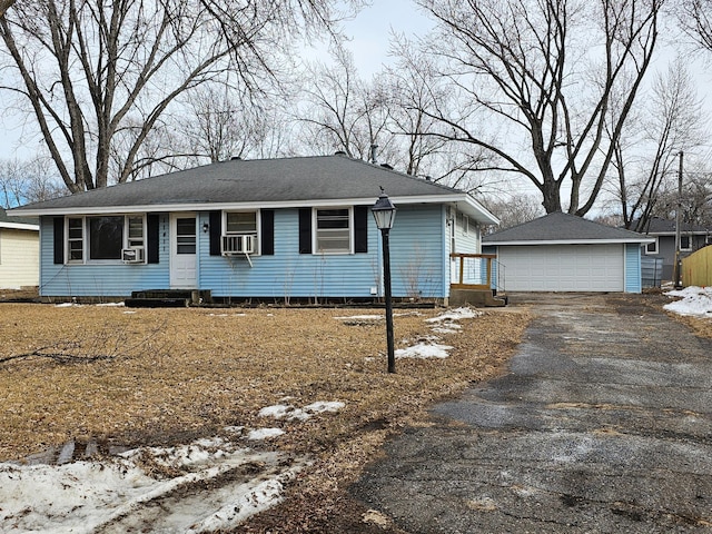 ranch-style house with entry steps, a detached garage, cooling unit, and an outdoor structure