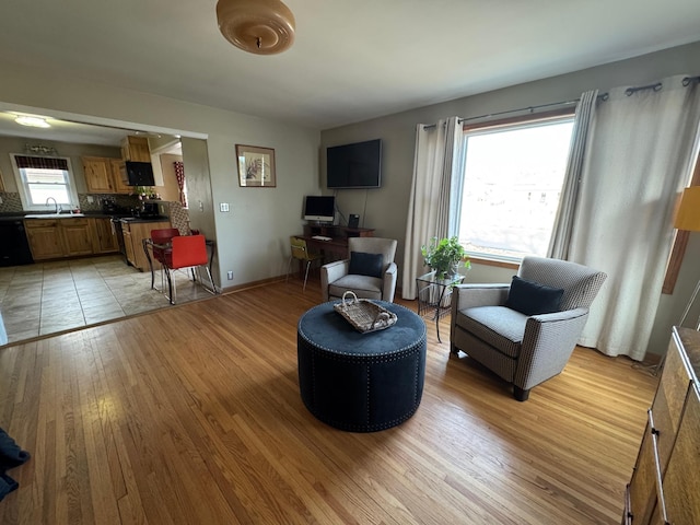 living area with light wood-style flooring and baseboards