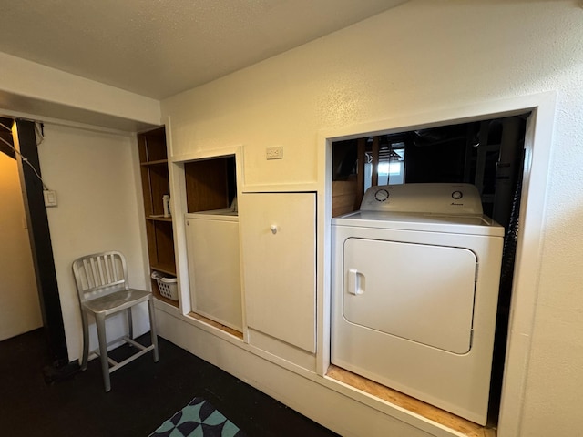 clothes washing area featuring a textured wall, laundry area, and washer / dryer