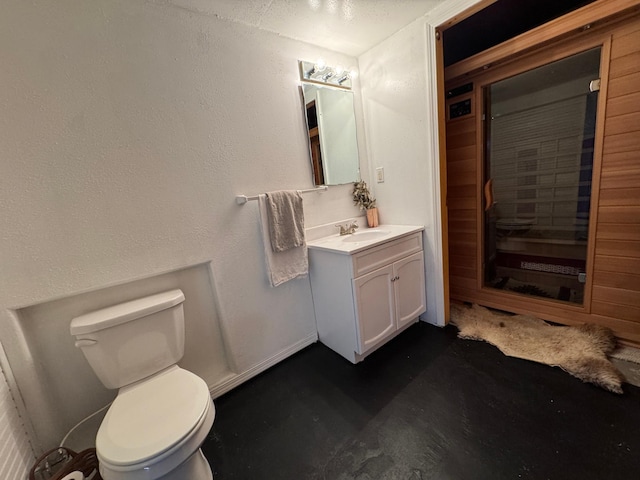 bathroom with concrete flooring, vanity, and toilet