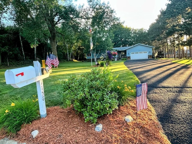 exterior space with driveway, a front lawn, and an attached garage