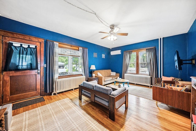 living area with a healthy amount of sunlight, radiator heating unit, and a wall unit AC