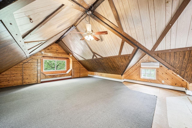 additional living space with wood walls, a wall mounted air conditioner, lofted ceiling, and a healthy amount of sunlight