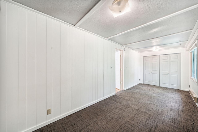 interior space with a closet, a textured ceiling, and baseboards