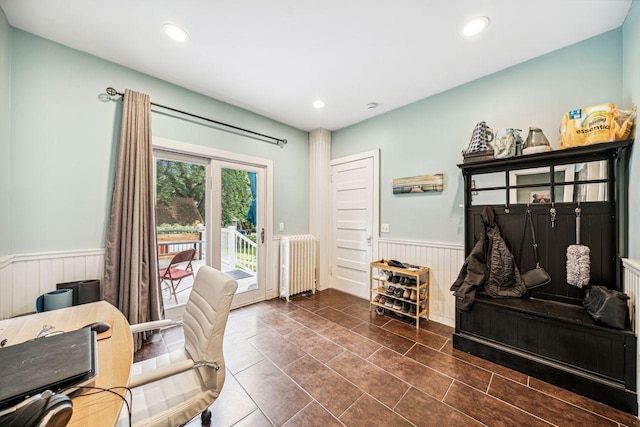 interior space featuring radiator, recessed lighting, and wainscoting