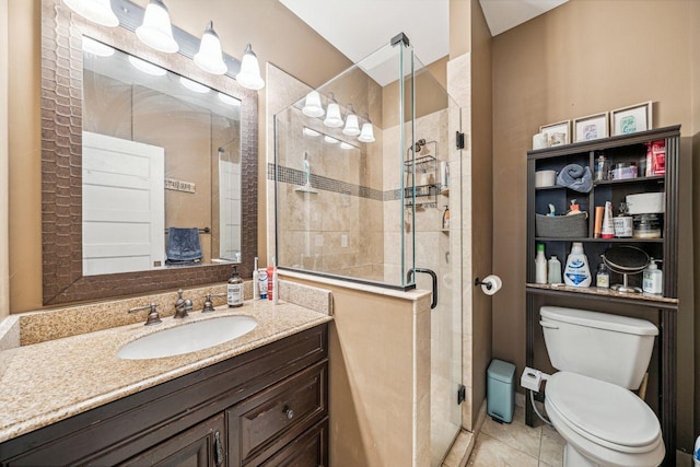 bathroom with vanity, tile patterned floors, toilet, and tiled shower