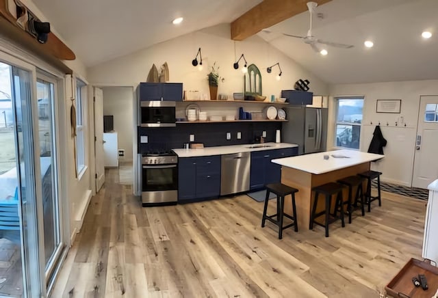 kitchen featuring lofted ceiling with beams, stainless steel appliances, and blue cabinets