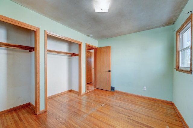 unfurnished bedroom with light wood-type flooring and baseboards