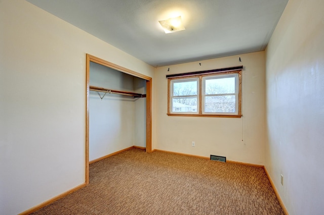 unfurnished bedroom with baseboards, a closet, and carpet flooring