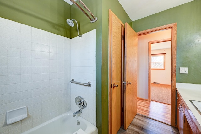 bathroom with bathtub / shower combination, vanity, and wood finished floors