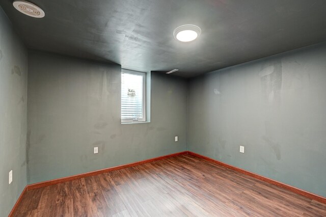 empty room featuring baseboards and wood finished floors