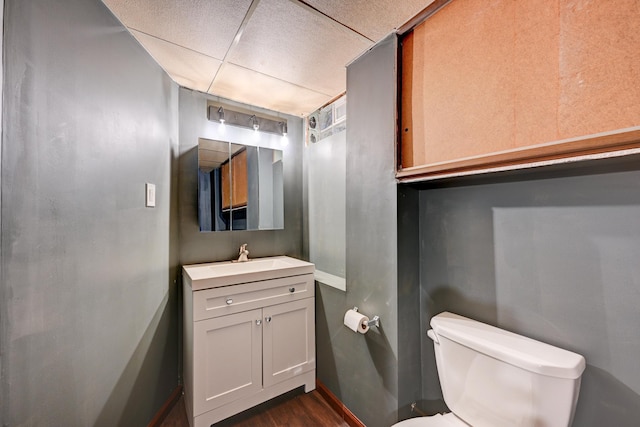 bathroom featuring a drop ceiling, vanity, toilet, and wood finished floors