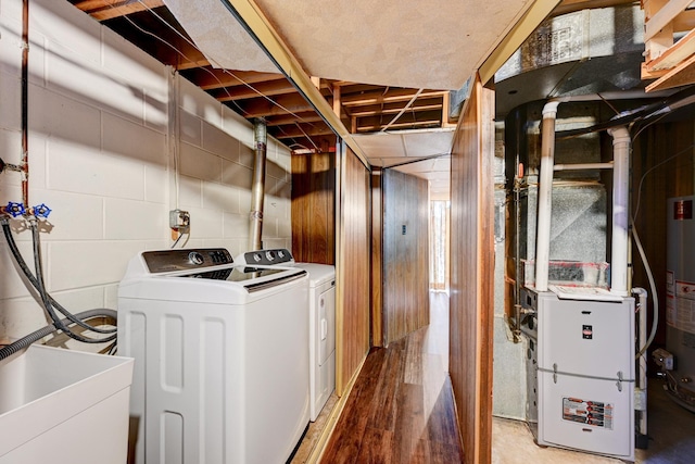 laundry area featuring washing machine and dryer, laundry area, a sink, light wood-style floors, and concrete block wall