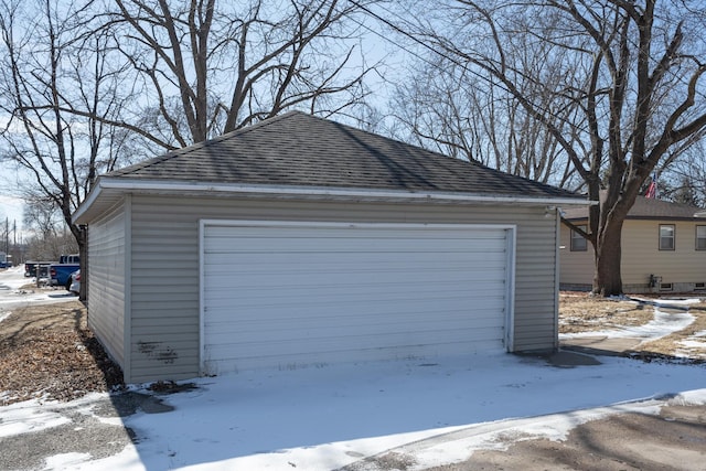 snow covered garage with a garage