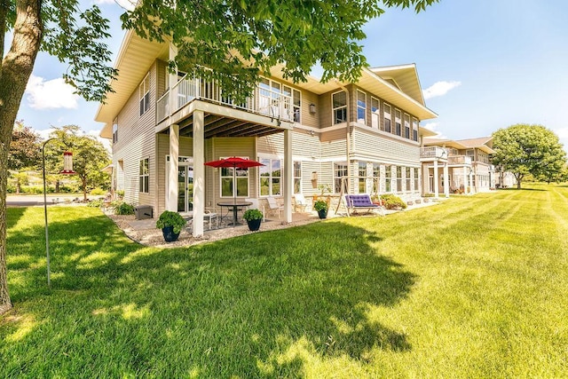 back of house with a yard, a balcony, and a patio area