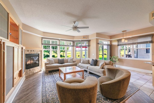 living area featuring a healthy amount of sunlight, a fireplace, and a textured ceiling