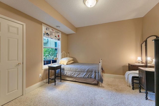 carpeted bedroom featuring baseboards and a textured ceiling