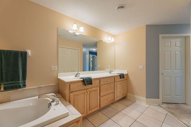 full bathroom with a garden tub, a sink, a textured ceiling, tile patterned flooring, and double vanity