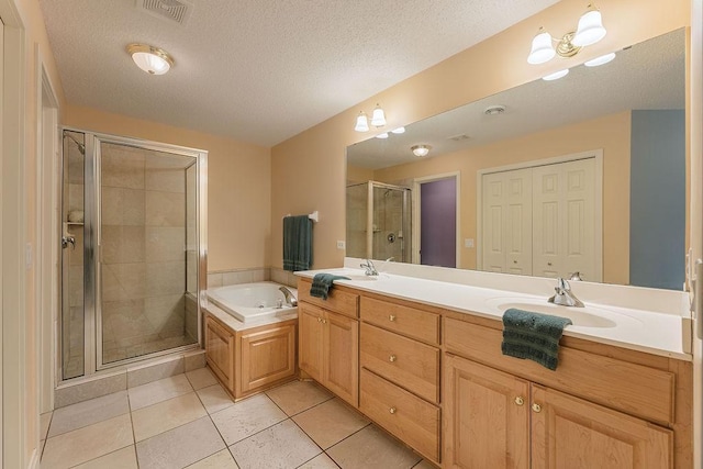 full bathroom featuring visible vents, a garden tub, a sink, a textured ceiling, and a shower stall