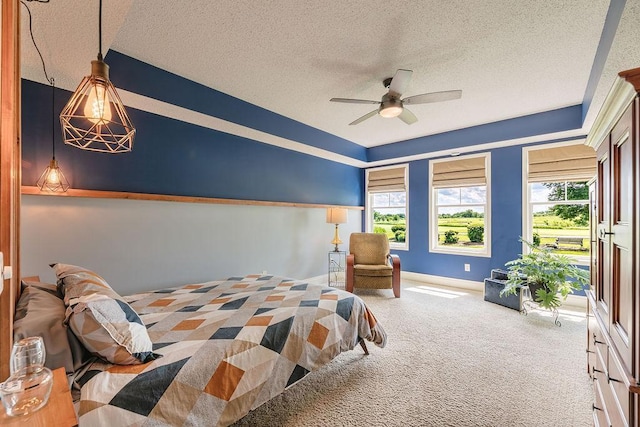 bedroom featuring baseboards, a textured ceiling, carpet, and a ceiling fan