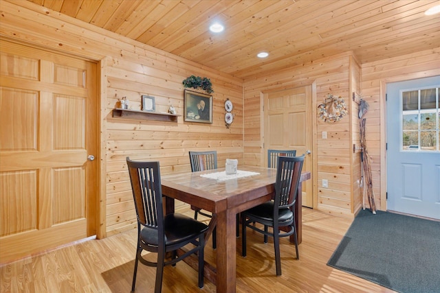 dining room featuring recessed lighting, light wood-type flooring, wooden walls, and wood ceiling