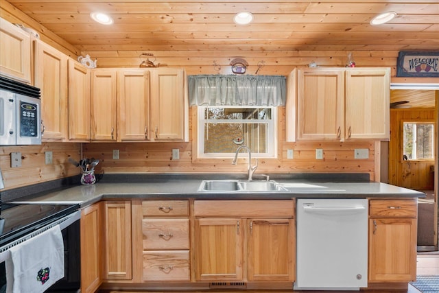 kitchen featuring wooden walls, light brown cabinets, wood ceiling, stainless steel appliances, and a sink