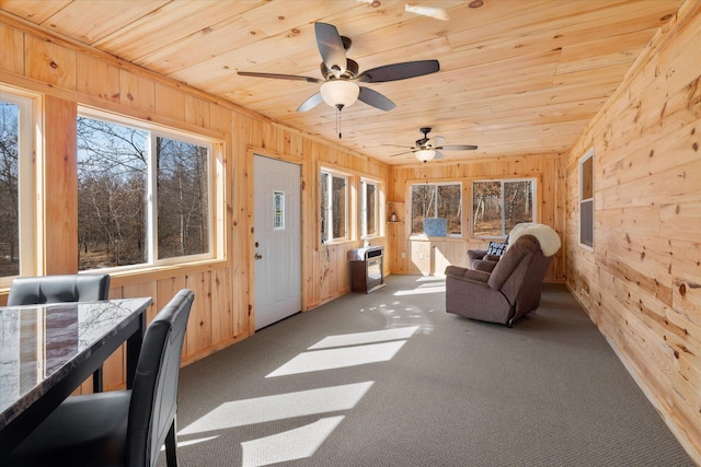 unfurnished sunroom featuring wood ceiling and a ceiling fan