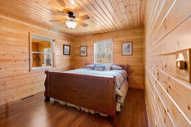 bedroom featuring wooden ceiling, wood finished floors, visible vents, and wood walls