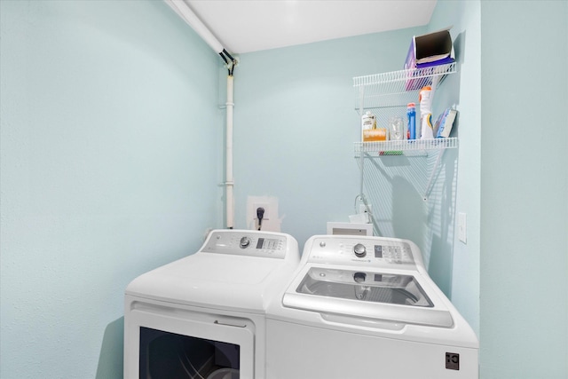 clothes washing area with washer and clothes dryer and laundry area