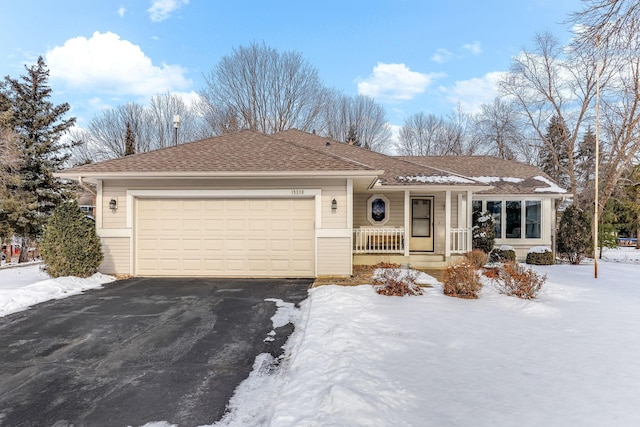 ranch-style house featuring an attached garage, covered porch, driveway, and a shingled roof