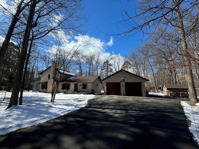 view of front of house with an outbuilding, driveway, and a garage