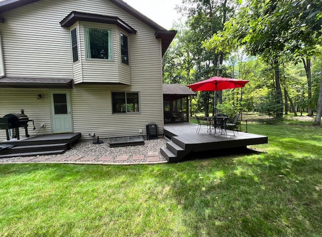 back of house featuring a lawn and a wooden deck