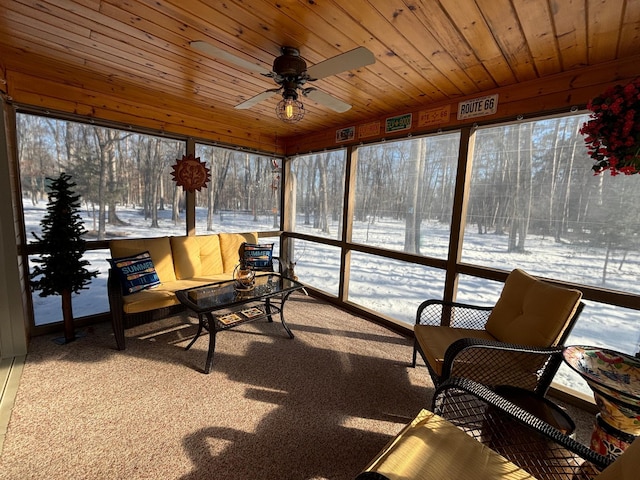 sunroom featuring wood ceiling and a ceiling fan