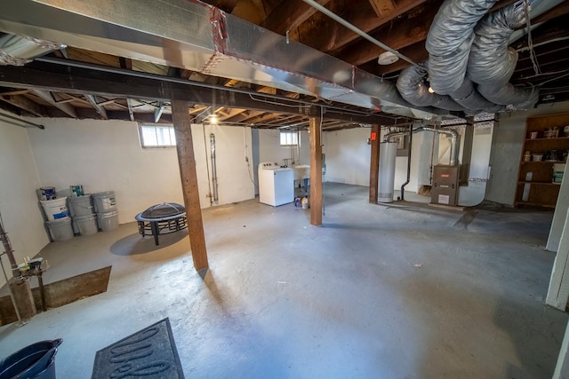 basement featuring gas water heater, washer / dryer, and heating unit