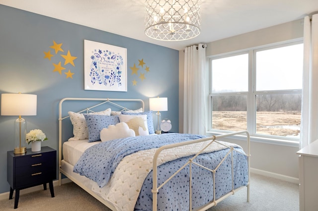 bedroom with a notable chandelier, carpet flooring, and baseboards