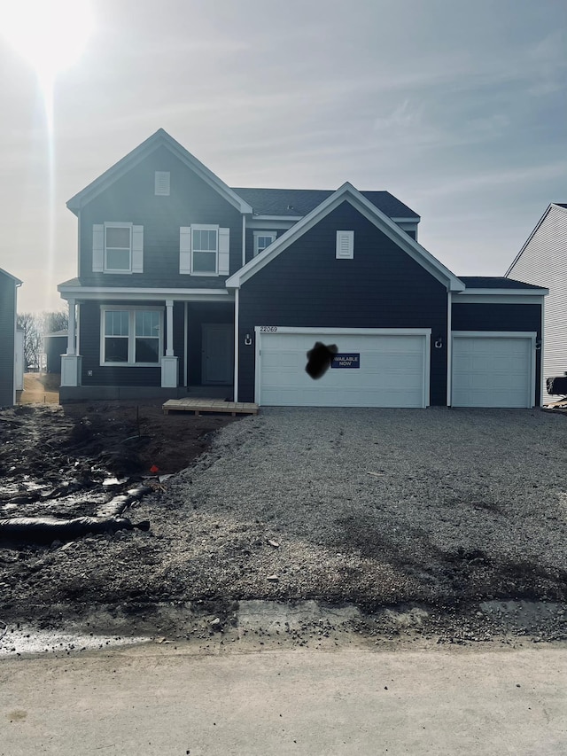 view of front facade featuring a porch, driveway, and an attached garage